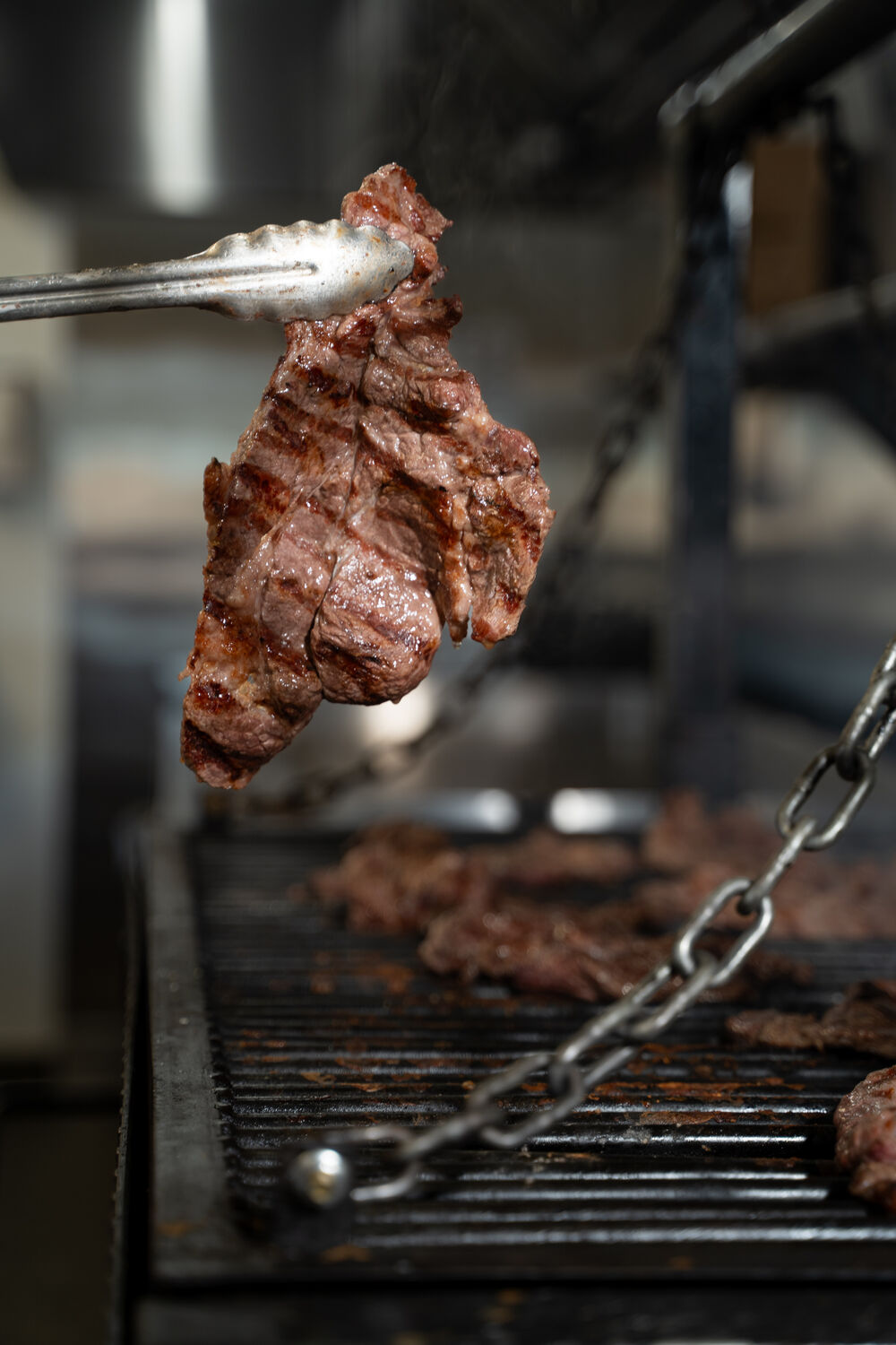 Grilled meat on tongs