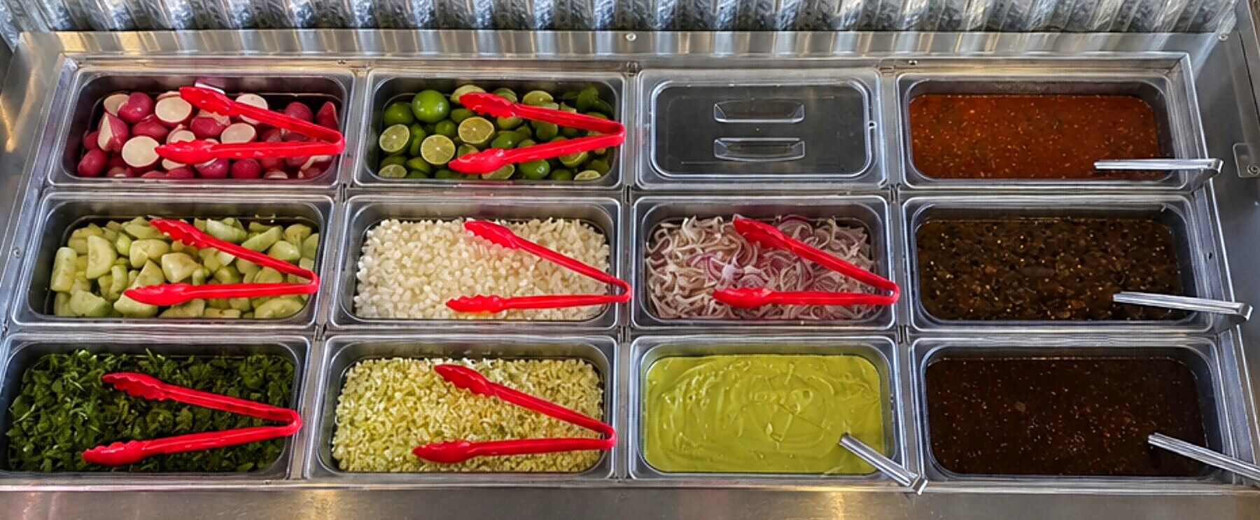 Taqueria Chicali fresh salsa bar with radishes, limes, cucumber, onion, cilantro, and three house-made salsas