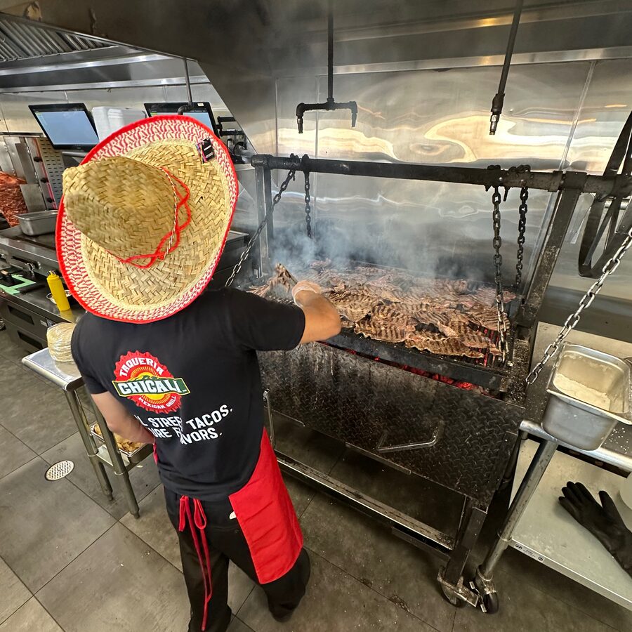 Cooking on the mesquite grill at Taqueria Chicali
